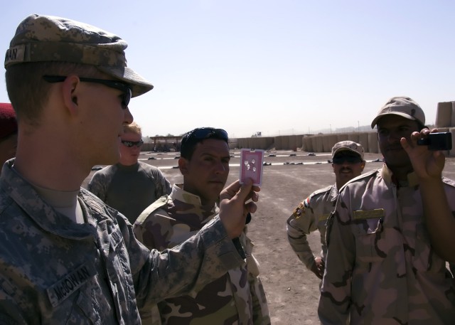 BAGHDAD - Sgt. Joseph McGowan, of Carlisle, Pa., serving with the 2nd Battalion, 112th Infantry Regiment "Paxton Rangers," 2nd Heavy Brigade Combat Team, 1st Infantry Division, Multi-National Division-Baghdad shows a group of Iraqi Army Soldiers...