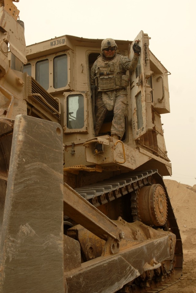 BAGHDAD - Spc. Franklin Cardenas, Army Reserve heavy equipment operator assigned to the 277th Engineer Company, 46th Eng. Bn., 225th Eng. Bde., exits from a D-9 bulldozer after clearing an area of rocks in northeast Baghdad, July 30. The D-9 bulldoze...