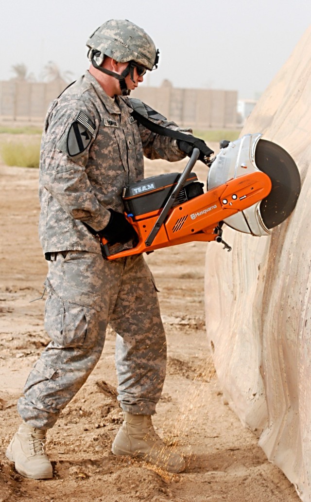 CAMP TAJI, Iraq-Pvt. Joshua Tompkins, of Enterprise, Ala., an aircraft sheet metal mechanic for Company B, 615th Aviation Support Battalion, 1st Air Cavalry Brigade, 1st Cavalry Division, Multi-National Division - Baghdad, makes his first cut into a ...