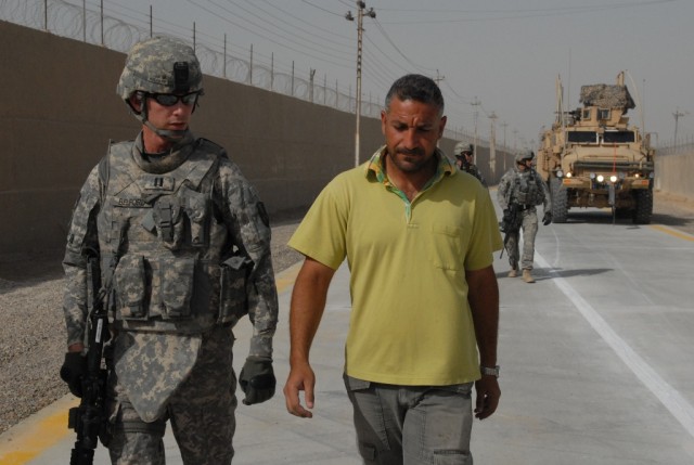 BAGHDAD - Capt. Steven Belford, Pineville, La. project manager for 225th Eng. Bde., speaks to the Maya Road contractor while conducting a final inspection before the road opening Aug 1. The 120 day project turned a pothole haven into a newly finished...