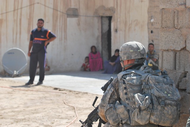 SHAKKAT, Iraq - Spc. Corey Daniel, of Shelbyville, Ind., checks his sector looking for anything suspicious while his Iraqi Army partners search a nearby building during Operation Mufa-Ja'ah, a combined air assault mission, July 31 in the small...