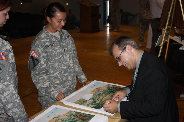 Staff Sgt. Andrea Alvarado, assigned to the 4th Brigade Combat Team, 1st Cavalry Division, receives a signed copy of the "Advise and Assist" Brigade Print, which visually summarizes the dedication, hard work and commitment the Soldiers demonstrated o...