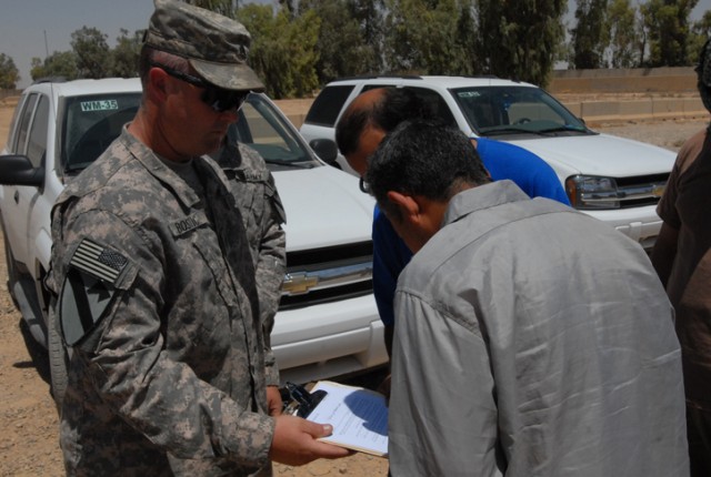 Staff Sgt. Ronald Bostic, a Homestead, Fla. native with 2nd Brigade Combat Team, 1st Cavalry Division provost marshal office, prepares documents releasing an Iraqi detainee at Forward Operating Base Warrior, Kirkuk, Iraq, July 18. The detainee...