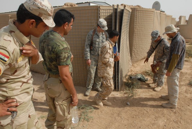 Iraqi Army soldiers listen as an instructor from 1st Battalion, 8th Cavalry Regiment, 2nd Brigade Combat Team, 1st Cavalry Division, shows them the structure of an Improvised Explosive Device and explains how to detect one. These IA soldiers are...