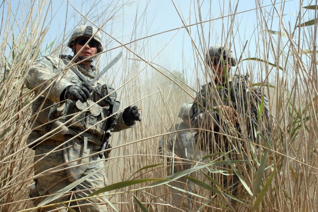 BAGHDAD - Spc. Richard Olin (left), a cavalry scout from Metlakatla, Ala., uses his machete to chop through dense underbrush as Staff Sgt. Jacob Marsters (right), from Albuquerque, N.M., and Staff Sgt. Michael Cedre (center), from Tucson, Ariz., both...