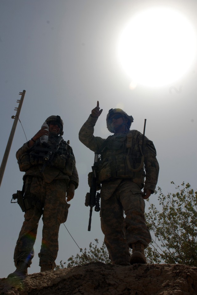 BAGHDAD - Staff Sgt. Jacob Marsters (left), a cavalry scout squad leader from Albuquerque, N.M., listens as Staff Sgt. Michael Cedre (right), a cavalry scout section sergeant from Tucson, Ariz., points out suspected areas of enemy routes during a pat...