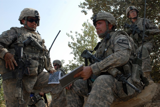 BAGHDAD - Maj. Gen. Daniel Bolger (right background), the commanding general for Multi-National Division - Baghdad, from Aurora, Ill., pulls security as 1st Lt. Jed Sargent, a platoon leader from Stark, N.H., discusses possible areas for observation ...