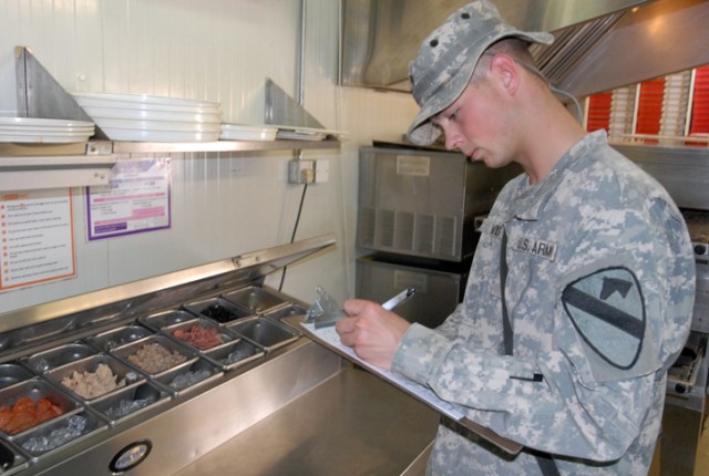 Spc. Jeffrey Davis, a Springfield, Mo., native and a preventive health specialist with Company C, 15th Brigade Support Battalion, 2nd Brigade Combat Team,1st Cavalry Division, examines a food preparation table at a food vendor on Forward Operating Ba...