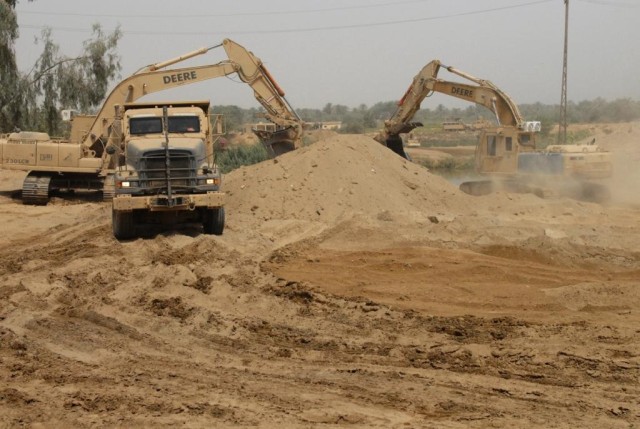 TAJI, Iraq - Dump trucks and hydraulic excavators remove some of the 6,000 cubic yards of dirt to prepare the banks of the Tigris for a Mabey Johnson Float Bridge. The 277th Engineer Company, 46th Engineer Battalion, 225th Engineer Brigade is in...