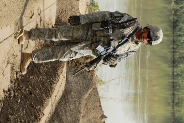 TAJI, Iraq - Sgt. Adam Deluna ,of San Antonio, Texas, stands watches on the banks of the Tigris River, north of Baghdad. The 277th Engineer Company, 46th Engineer Battalion, 225th Engineer Brigade Soldier is in charge of the project and said this...