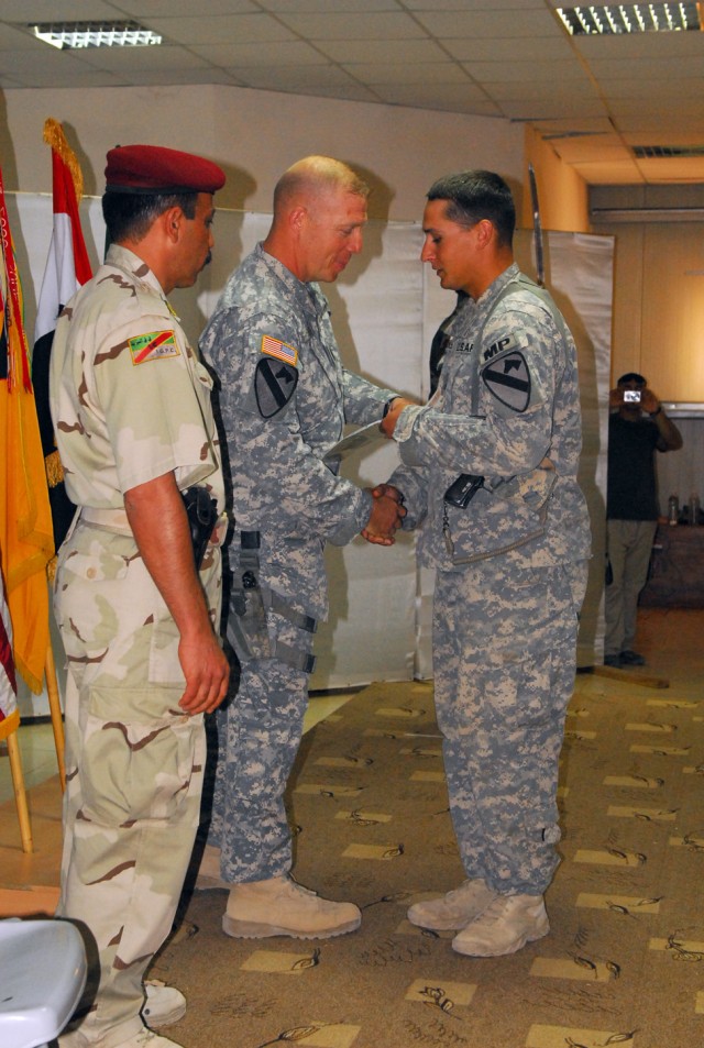 Sgt. Joshua Chandler, an Antrim, N.H. native and military policeman with 2nd Brigade Combat Team, 1st Cavalry Division, is congratulated by Command Sgt. Maj. Jeffery Hof (center) and Command Sgt. Maj. Waleed Ibrahim Ismael (left), the top enlisted So...