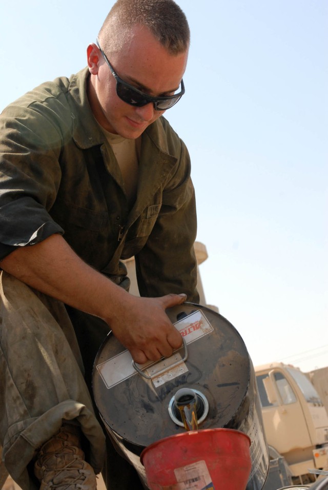 BAGHDAD - Broken Arrow, Okla. native, Pfc. Matthew Smith, Bradley mechanic for Co. A, 2nd Battalion, 5th Cavalry Regiment, 1st Brigade Combat Team, 1st Cavalry Division, refills oil on a humvee during preventative maintenance checks and services Aug....