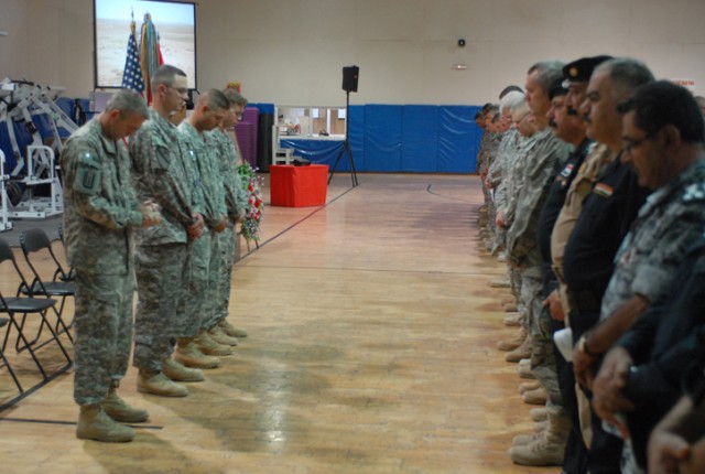 Soldiers, Airmen, Iraqi Police, Iraqi Army and civilians bow their heads in remembrance of Sgt. 1st Class Johnny Polk during a memorial service in his honor at Forward Operating Base Warrior, Kirkuk, Iraq, August 8. Polk died July 31 from wounds...