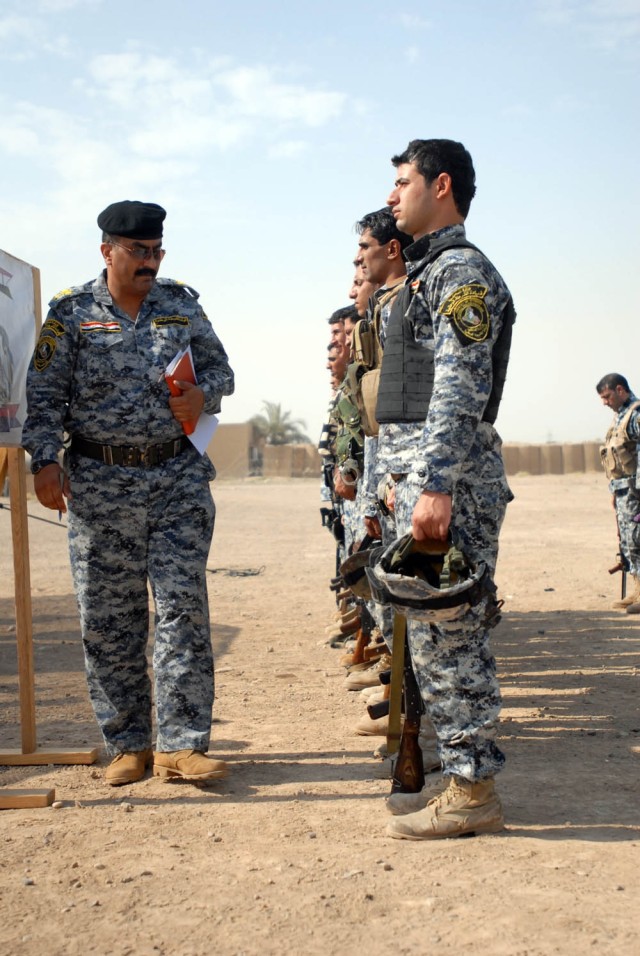 BAGHDAD - The 2nd Federal Police Brigade commander (left) examines each Federal Policemen individually to ensure they are within the uniform regulation as part of the Wolf Academy at Joint Security Station Istiqlaal Aug. 12. Soldiers from Troop C,...