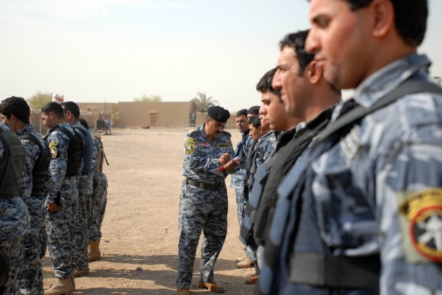 BAGHDAD - The 2nd Federal Police Brigade commander (left) examines each Federal Policemen individually to ensure they are within the uniform regulation as part of the Wolf Academy at Joint Security Station Istiqlaal Aug. 12. Soldiers from Troop C,...