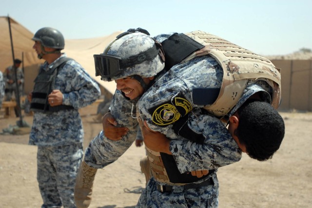 BAGHDAD - Federal Policemen from the 1st and 2nd Battalions, 2nd Federal Police Brigade practice a fireman carry during the Wolf Academy at Joint Security Station Istiqlaal Aug. 12. Soldiers assigned to Troop C, 1st "Garryowen" Squadron, 7th...