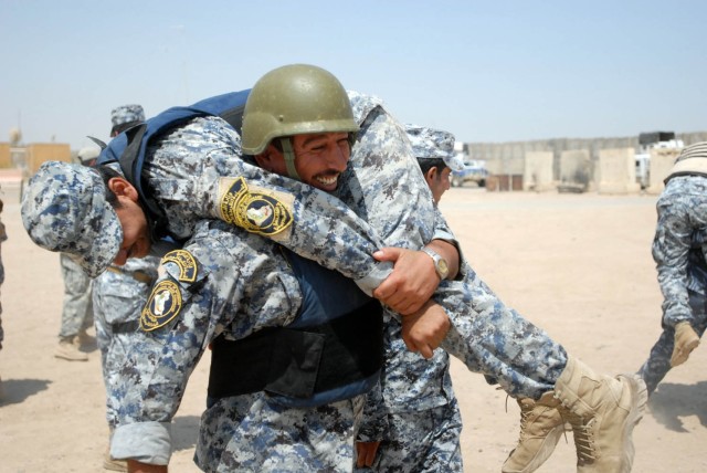 BAGHDAD - Federal Policemen from the 1st and 2nd Battalions, 2nd Federal Police Brigade practice a fireman carry during the Wolf Academy at Joint Security Station Istiqlaal Aug. 12. Soldiers assigned to Troop C, 1st "Garryowen" Squadron, 7th...