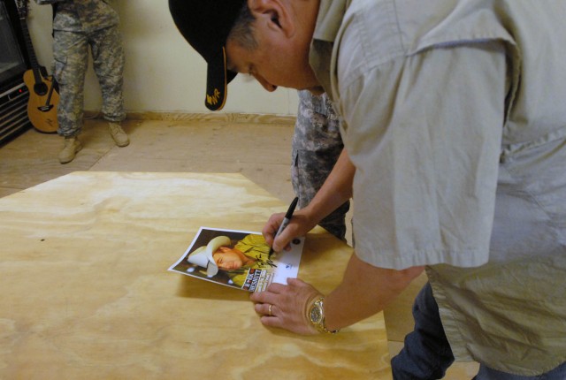 BAGHDAD- Country music star Mark Chesnutt autographs a photo for a fan during a visit to Joint Security Station War Eagle Aug. 14.  Several Soldiers from the Ft. Hood, Texas based 1st Brigade Combat Team, 1st Cavalry Division, reminisced about...
