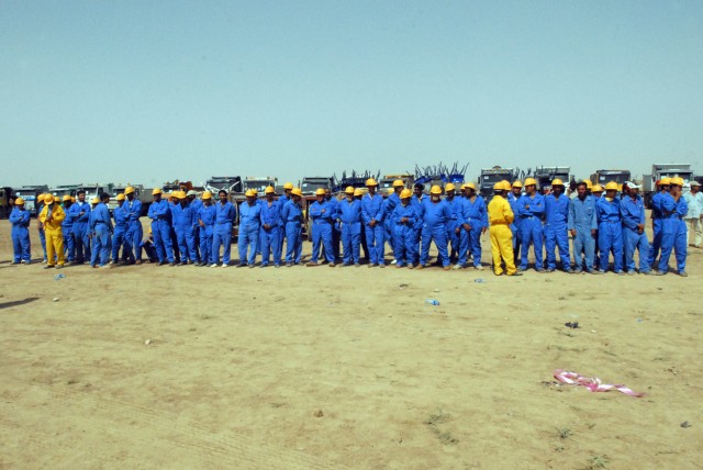 Iraqi workers stand in front of their waste removal trucks during a ribbon cutting ceremony  in Kirkuk city, Iraq, August 9, to commemorate a two-month beautification project set to educate residents on proper waste disposal and remove trash and...