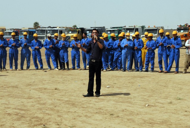 An Iraqi singer entertains the crowd as Iraqi workers stand in front of their waste removal trucks during a ribbon cutting ceremony in Kirkuk city, Iraq, August 9, to commemorate a two-month beautification project set to educate residents on...