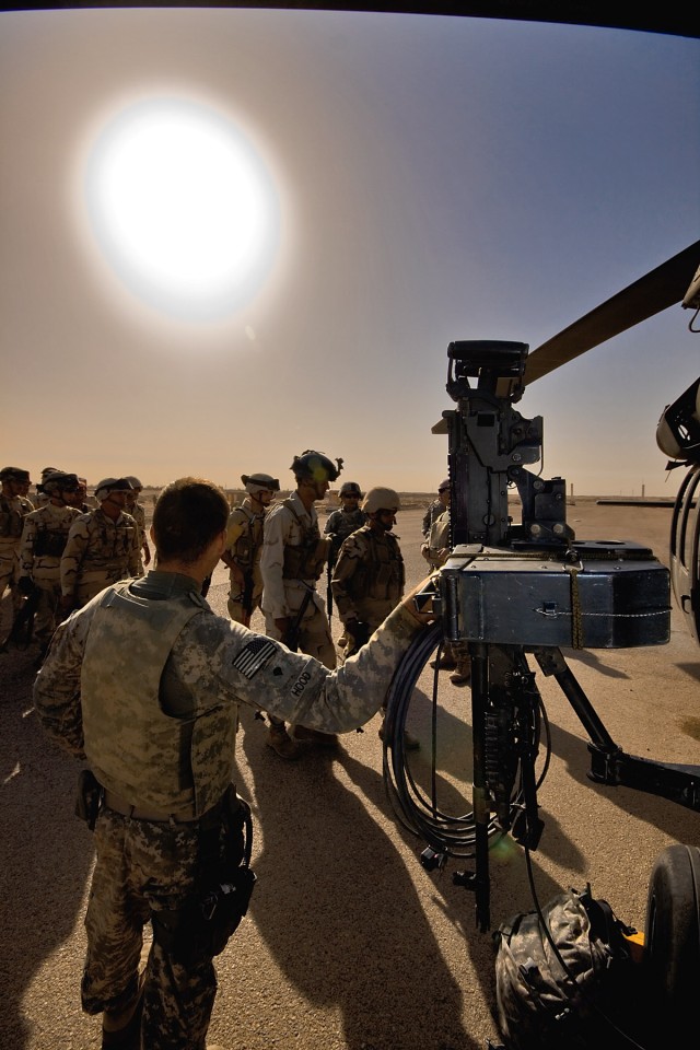 CAMP TAJI, Iraq-Underneath the morning sun, UH-60 Black Hawk crew chiefs from Company B, 3rd Battalion, 227th Aviation Regiment, 1st Air Cavalry Brigade, 1st Cavalry Division, Multi-National Division - Baghdad, begin to load Iraqi Army Soldiers...