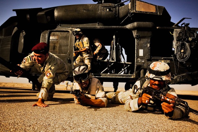 CAMP TAJI, Iraq-Rushing out of a UH-60 Black Hawk helicopter, Iraqi Soldiers hit the ground and take up security positions during a training exercise Aug. 18, Baghdad, Iraq. The Black Hawks and training were provided by Company B, 3rd Battalion,...
