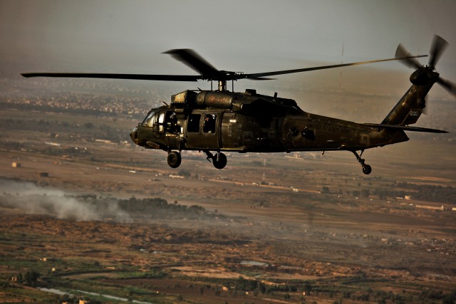 CAMP TAJI, Iraq-Smoke clouds cover the horizon and early morning fog covers the ground as a UH-60 Black Hawk helicopter from Company B, 3rd Battalion, 227th Aviation Regiment, 1st Air Cavalry Brigade, 1st Cavalry Division, Multi-National Division...