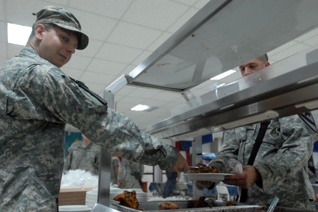 BAGHDAD - Coldwater, Mich. native, Pfc. Justin DeWitt, a cook assigned to Forward Support Company E, 1st Battalion, 5th Cavalry Regiment, attached to the 1st "Ironhorse" Brigade Combat Team, 1st Cavalry Division, serves dinner, Aug. 16, at Joint...