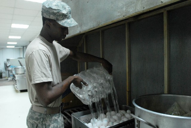 BAGHDAD - Newport, R.I. native, Pfc. Andre Barrett, cook assigned to 1st Battalion, 5th Cavalry Regiment, attached to the 1st "Ironhorse" Brigade Combat Team, 1st Cavalry Division, pours water over eggs to boil them for breakfast, Aug. 18, at...
