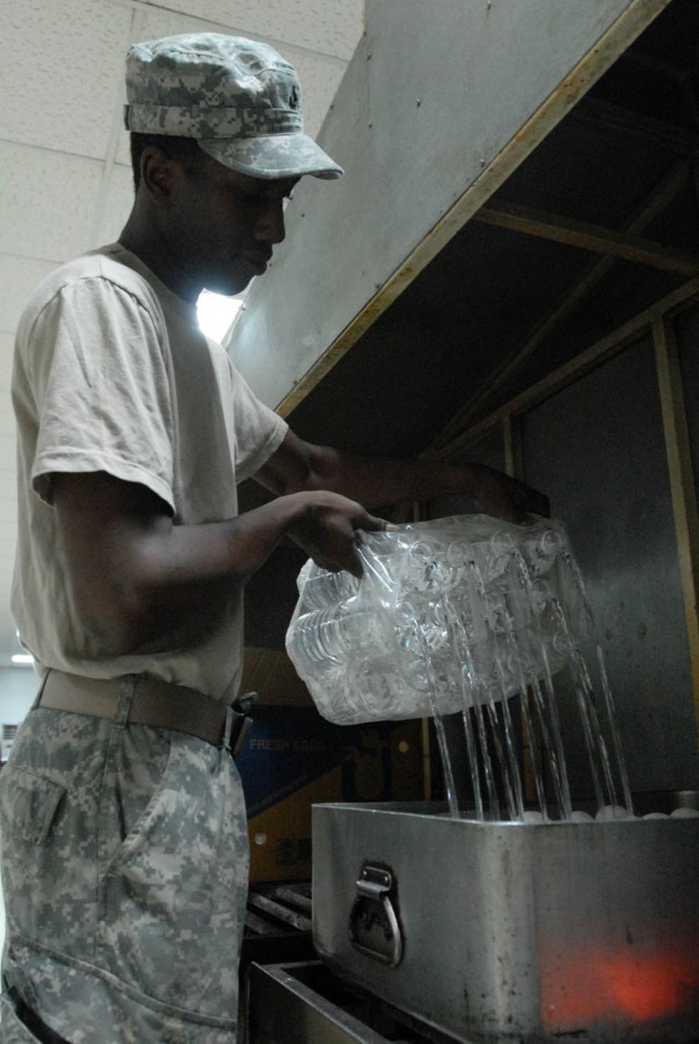 BAGHDAD - Newport, R.I. native, Pfc. Andre Barrett, cook assigned to 1st Battalion, 5th Cavalry Regiment, attached to the 1st "Ironhorse" Brigade Combat Team, 1st Cavalry Division, pours water over eggs to boil them for breakfast, Aug. 18, at...