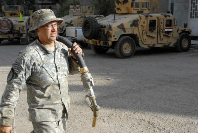 BAGHDAD - San Antonio native, Spc. Andres Lopez, a fueler assigned to Company A, 115th Brigade Support Battalion, 1st Brigade Combat Team, 1st Cavalry Division, pulls a fuel hose from a Heavy Expanded Multiple Mobility Truck (HEMMT) as he prepares...