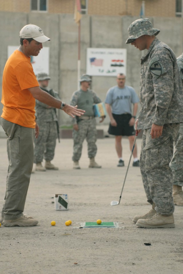 BAGHDAD - Orlando, Fla. Native, Carl Paulson (left), a "Fairways 2 Greens" Golf Tour golf pro, advises Flatwoods, Tenn. Native, Pfc. Andrew Bunch (right), an intelligence personnel specialist assigned to Company A, 1st Brigade Special Troops...