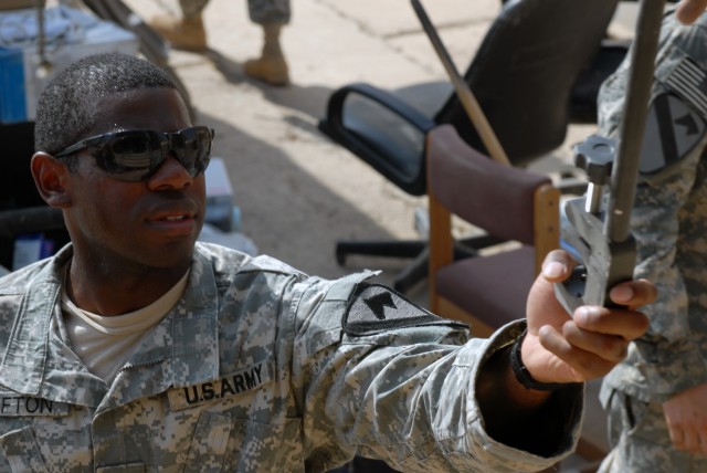 CAMP TAJI, Iraq - Houston native, Sgt. Everson Lofton, a noncommissioned officer in charge of supply assigned to Battery A, 1st Battalion, 82nd Field Artillery Regiment, 1st Brigade Combat Team, 1st Cavalry Division, grabs a tool from a truck as...