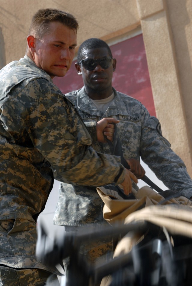 CAMP TAJI, Iraq - Copperas Cove, Texas native, Pfc. Kenneth Curtsinger (left), an artillery cannon crewmember,  and Houston native, Sgt. Everson Lofton (right), a non commissioned officer in charge of supply, both assigned to Battery A, 1st...
