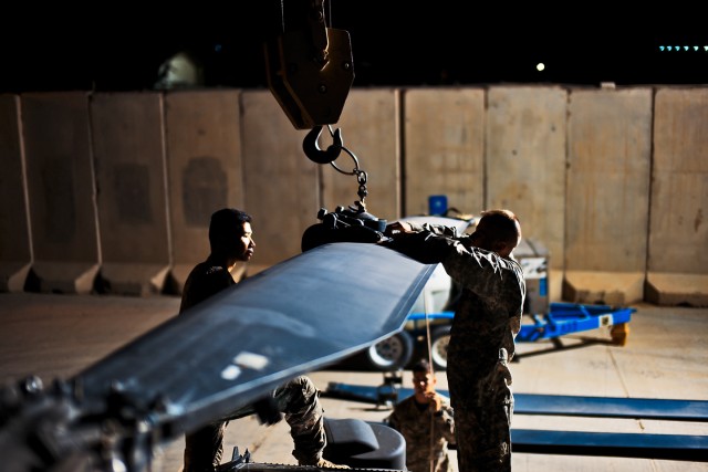 CAMP TAJI, Iraq-Before pulling the pins that hold a main rotor blade in position, Sgt. Russell Neal (right), from Lexington, Ky., an AH-64D Apache attack helicopter crew chief in Company A, 4th Battalion, 227th Aviation Regiment, 1st Air Cavalry...