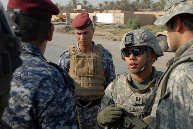 TAJI, Iraq - Little Rock, Ark. native Capt. Alex Aquino (center), commander of Battery B, 1st Battalion, 82nd Field Artillery Regiment, 1st Brigade Combat Team, 1st Cavalry Division, speaks with Lt. Col. Majid Hentan, commander of the al-Wenda...