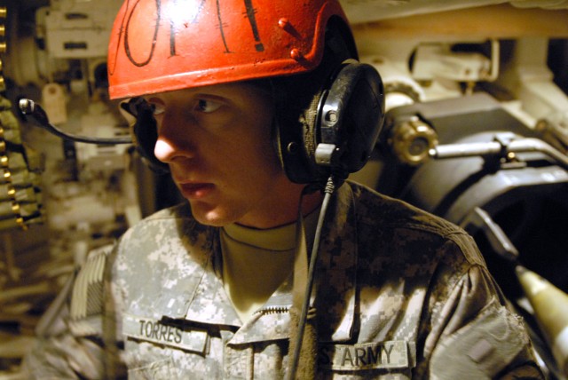 CAMP TAJI, Iraq - Cannon crewmember, Pfc. Justin Torres from Naples, Fla., assigned to Battery B, 1st Battalion, 82nd Field Artillery Regiment, 1st Brigade Combat Team, 1st Cavalry Division, gets ready to load a Paladin M109A2 to fire illumination...