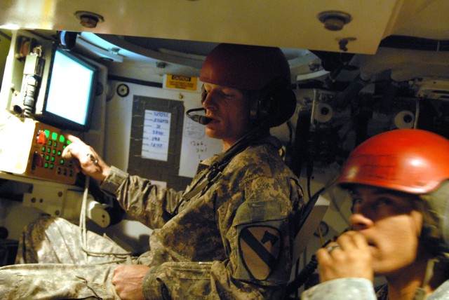 CAMP TAJI, Iraq - Sgt. Jeremy Wilder (left), a cannon crewmember section chief from Attalla, Ala., double checks the data he receives from the Base Defense Operations Center while Sgt. Matthew Keen, also a cannon crewmember and native of San...
