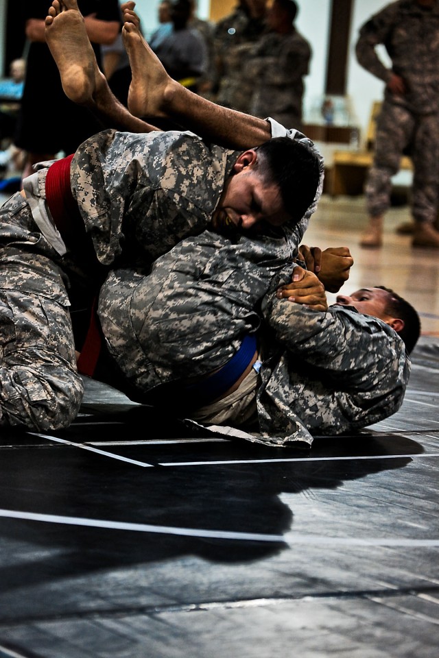 CAMP TAJI, Iraq-Staff Sgt. Nathaniel Landis (red belt), from Graham, Wash., the battalion motor pool sergeant for 615th Aviation Support Battalion, 1st Air Cavalry Brigade, 1st Cavalry Division, escapes a submission attempt by his oponent and goes...