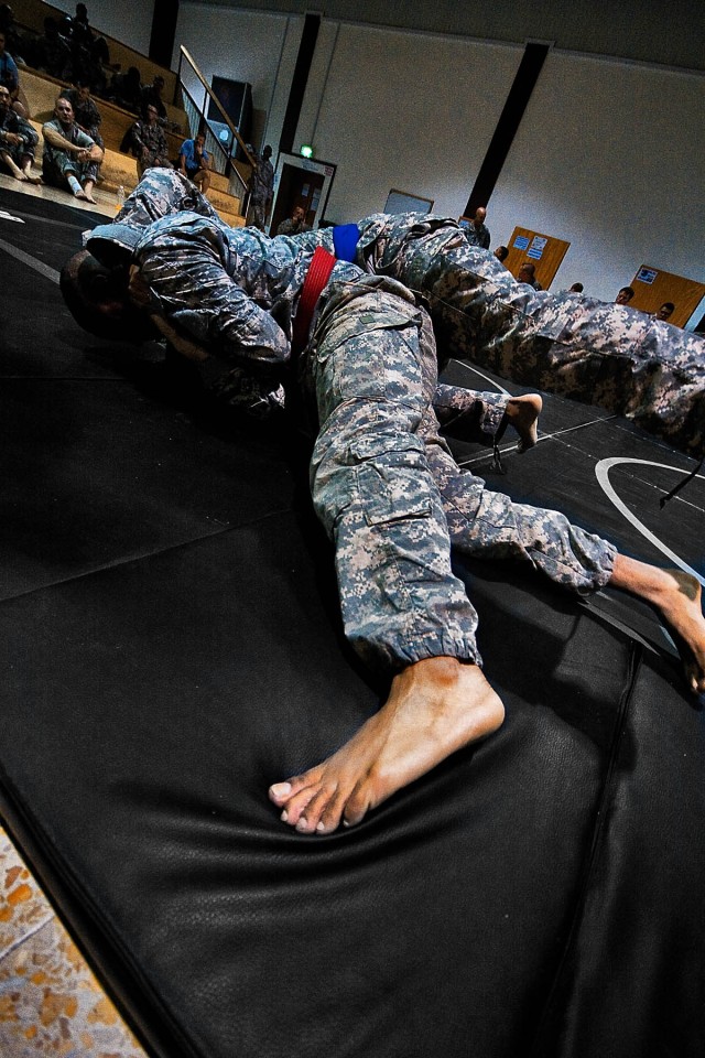 CAMP TAJI, Iraq-Spc. Ronnell Howard (red belt), from Fort Bragg, N.C., a mechanic for Headquarters Support Company, 615th Aviation Support Battalion, 1st Air Cavalry Brigade, 1st Cavalry Division, Multi-National Division - Baghdad, pulls his...