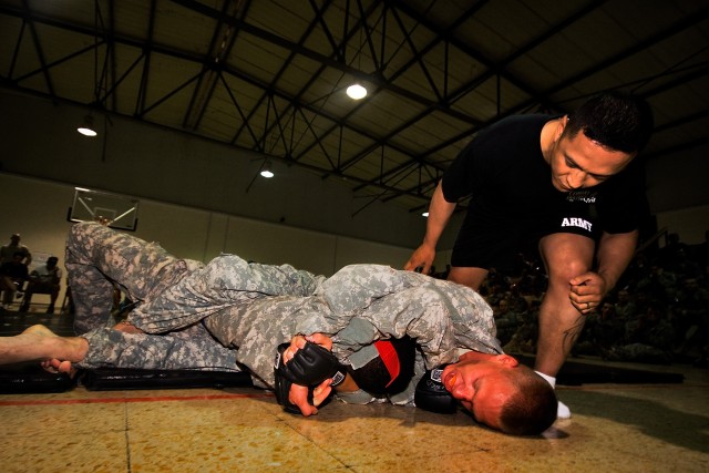 CAMP TAJI, Iraq-The referee watches closely as Spc. De Andre Jackson (being held inside), from San Francisco, a generator mechanic for Headquarters Support Company, 615th Aviation Support Battalion, 1st Air Cavalry Brigade, 1st Cavalry Division,...