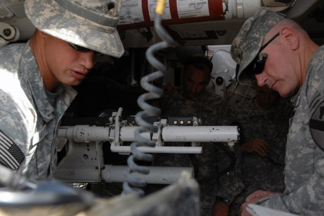 CAMP TAJI, Iraq- Killeen, Texas native, Spc. Kenneth Melton (left), an artillery cannon crewmember assigned to Battery B, 1st "Dragon" Battalion, 82nd Field Artillery Regiment, 1st Brigade Combat Team, 1st Cavalry Division, explains the different typ...
