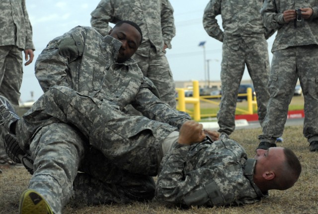 Two Soldiers, assigned to the 4th Special Troops Battalion, 1st Cavalry Division, practice a combatives technique called 'passing the guard'.  Pfc. Brent Moore, a level two certified combatives instructor, teaches Company A on Tuesday mornings in pre...