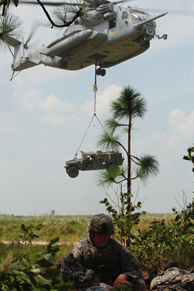 Marine aviators help Airborne Artillerymen get their Howitzers into battle