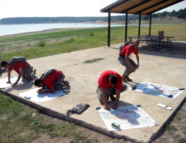 Soldiers, assigned to the 5th Battalion, 82nd Field Artillery Regiment, 4th Brigade combat Team, 1st Cavalry Division, review military maps in preparation for the third annual "Apache Olympics" Aug. 27. The Soldiers were one of six teams to...