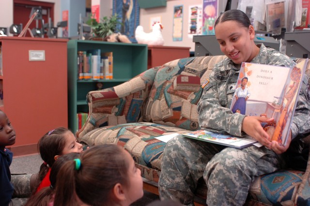 Spc. Jasmin Rodriquez reads a children's book to Seydou-Nour Konate, Valerie Candelelaria and Jadelyn Febles, pre-kindergarten students of Maxdale Elementary School in Killeen, Texas, Sept. 8.   Four 'Greywolf' Soldiers spent two hours with pre-K stu...