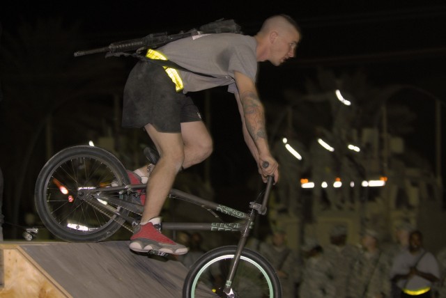CAMP LIBERTY, Iraq - Spc. Gary Keane, a light-wheeled vehicle mechanic with the 50th Expeditionary Signal Battalion, 160th Signal Brigade, rides his new BMX bike off a ramp after receiving it as a gift from pro BMX and skateboard athletes at the...