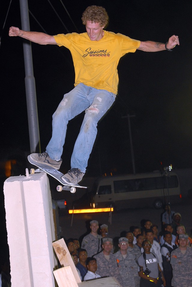 CAMP LIBERTY, Iraq -Multi-National Division - Baghdad Soldiers look on in awe as pro skateboarder, Jud Heald, from Joplin, Mo., performs a stall on a 15-foot high T-wall during the "Bikes Over Baghdad" tour at Camp Liberty, here, Sept. 9. The show...