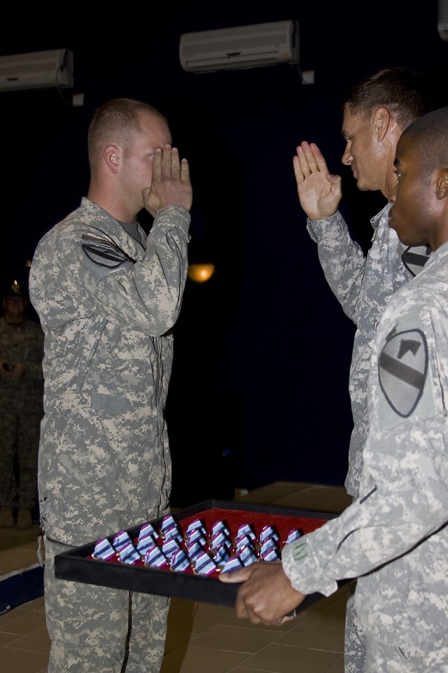 CAMP TAJI, Iraq-Brig. Gen. Frederick Rudesheim (center), the deputy commanding general of support, 1st Cavalry Division, Multi-National Division - Baghdad, presents the Humanitarian Service Medal to Sgt. Dustin Jeffcoat (left), from Canton, Texas,...