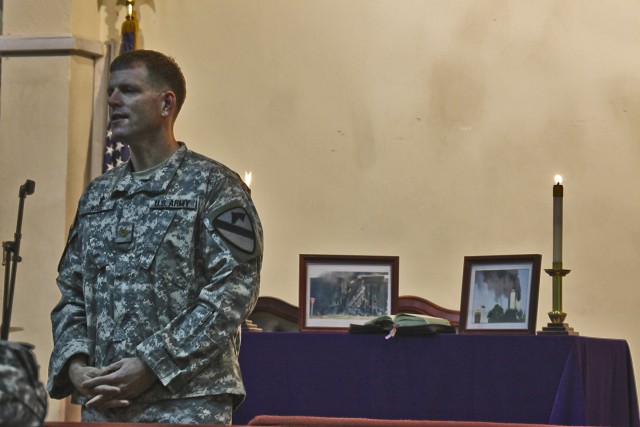 CAMP TAJI, Iraq-Images from the Sept. 11, 2001 attacks flank Chaplain (Maj.) Michael Wood, from Long Beach Island, N.J., 1st Air Cavalry Brigade, 1st Cavalry Division, Multi-National Division - Baghdad, as he speaks to Soldiers at a remembrance servi...